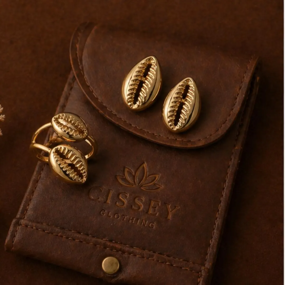 Set bijoux coquillage cauri dorés dans pochette en cuir Cissey Clothing