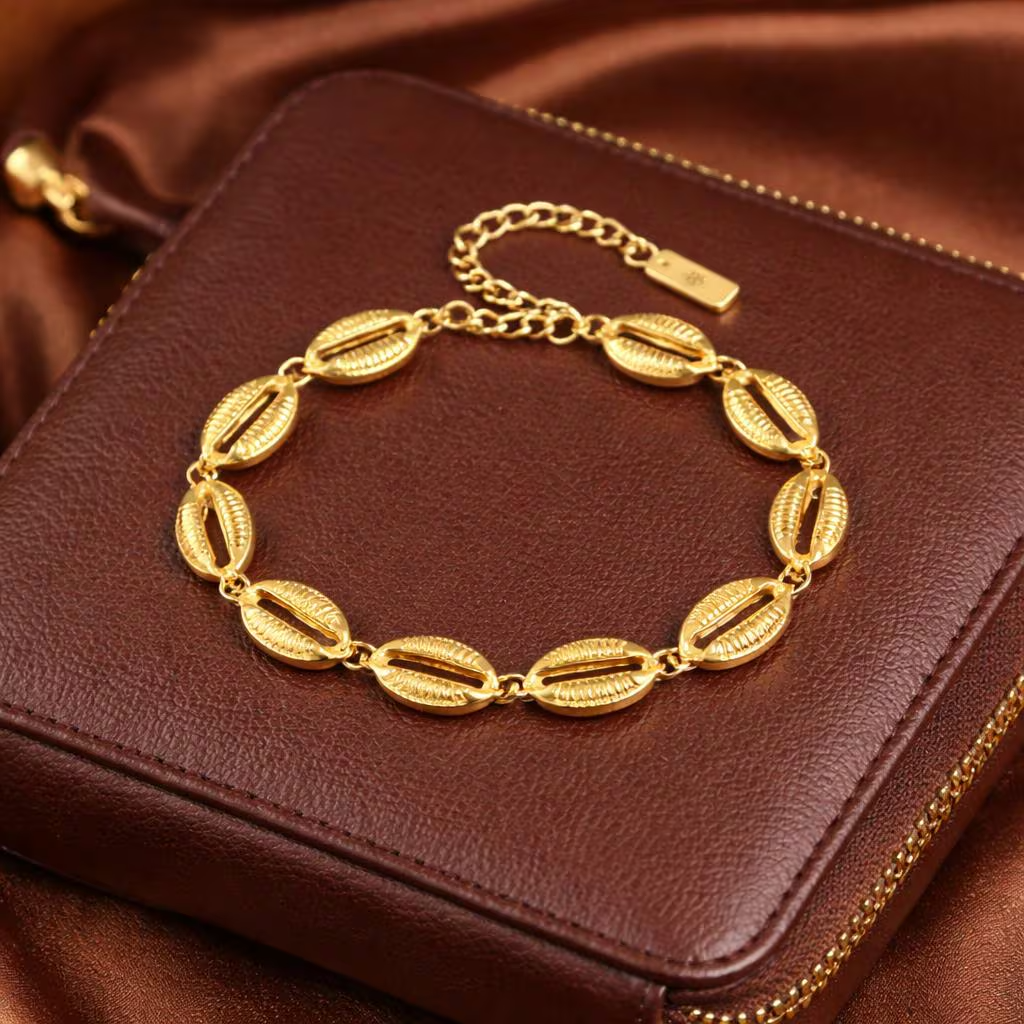 Bracelet chaîne coquillages cauri dorés sur pochette en cuir — Cissey Clothing